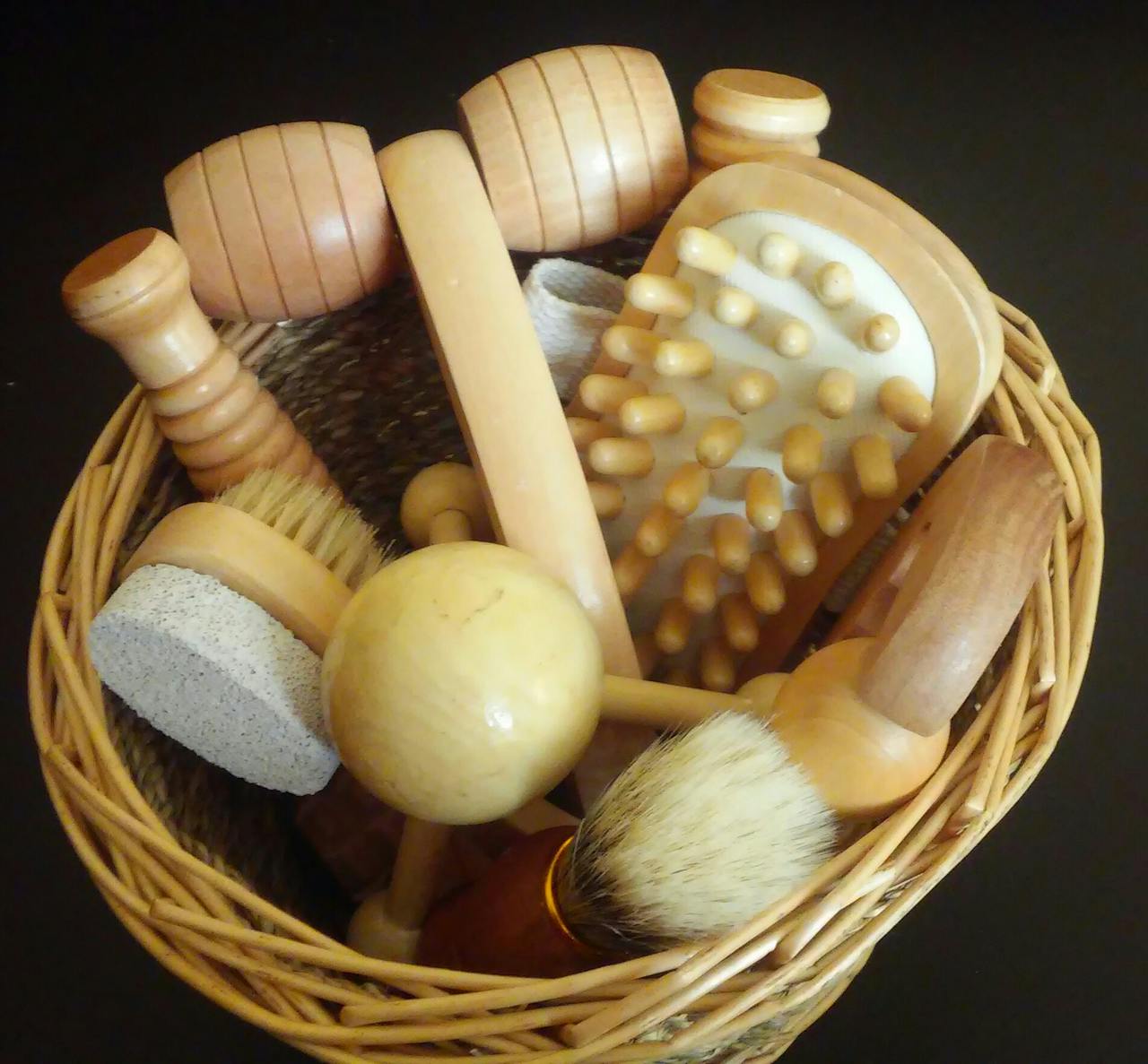 services-03 Top view of various wooden massage tools neatly arranged in a woven basket.
